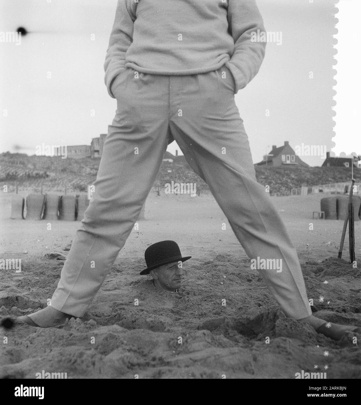 Situation étrange à la plage néerlandaise, homme avec corps entier dans le sable Date: 25 mai 1959 Banque D'Images