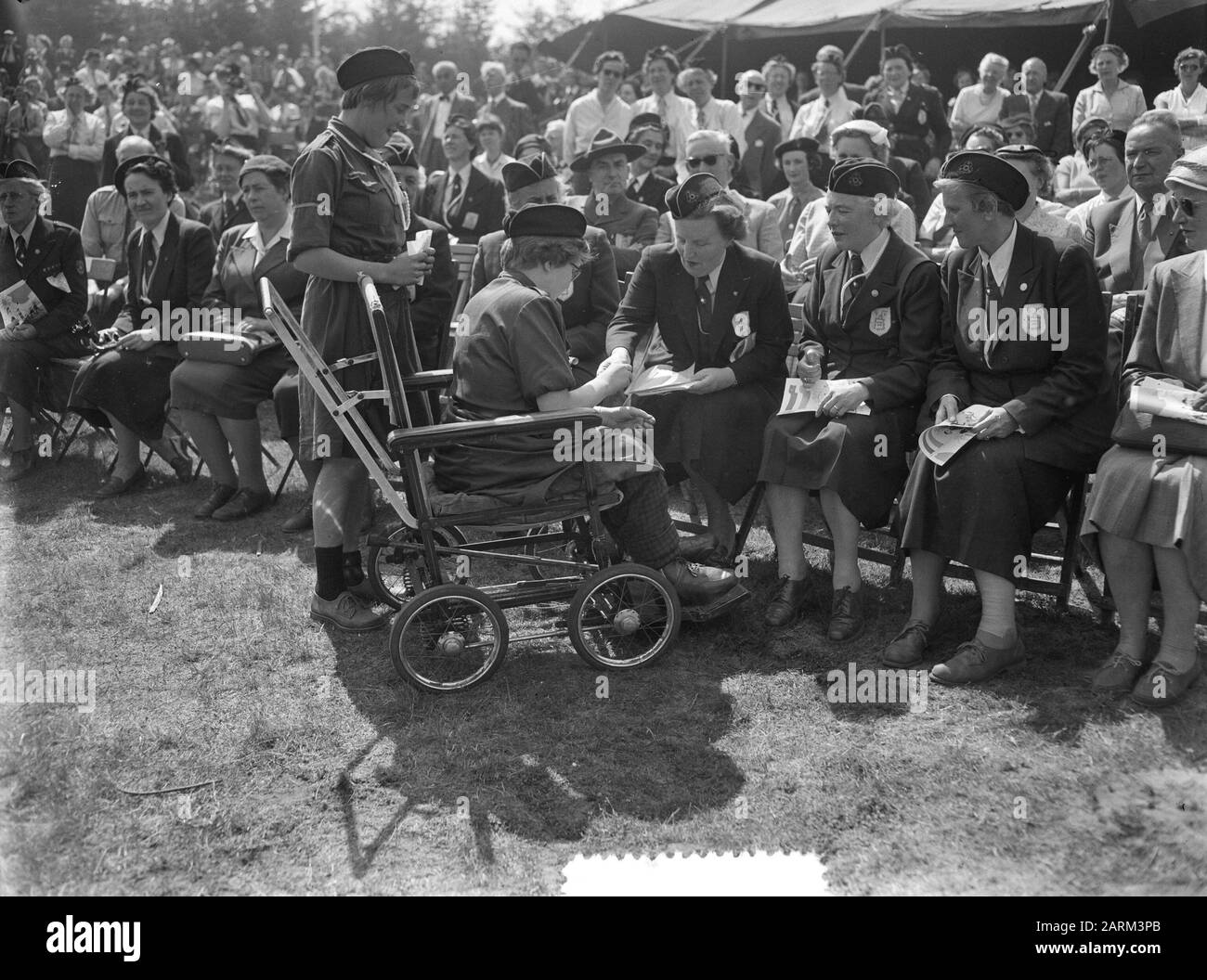 La reine Juliana et la princesse Marijke au Goudsberg à la Guilde néerlandaise du Scoutisme des garçons (N.P.G.) de 40 ans célébration du 40ème anniversaire N.P.G. sur le Goudsberg à Lunteren. La Reine Patronne Juliana donne quelque chose à un scout en fauteuil roulant Annotation: Juste à côté de la Reine Juliana le président de la NPG, Mme J. van Nispen-van Wely Date: 22 mai 1956 lieu: Déjeuner mots clés: Anniversaires, reines, scout, princesses Nom personnel: Juliana (Reine Pays-Bas) Nom de l'institution: Guilde Néerlandaise Du Scoutisme Des Garçons Banque D'Images