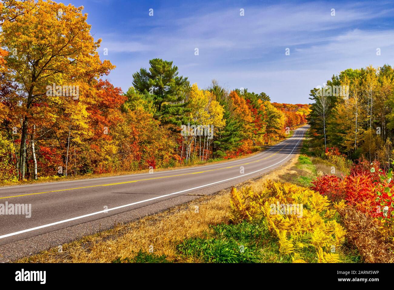 Une autoroute aux couleurs éclatantes du feuillage d'automne près de Minocqua, Wisconsin, États-Unis. Banque D'Images