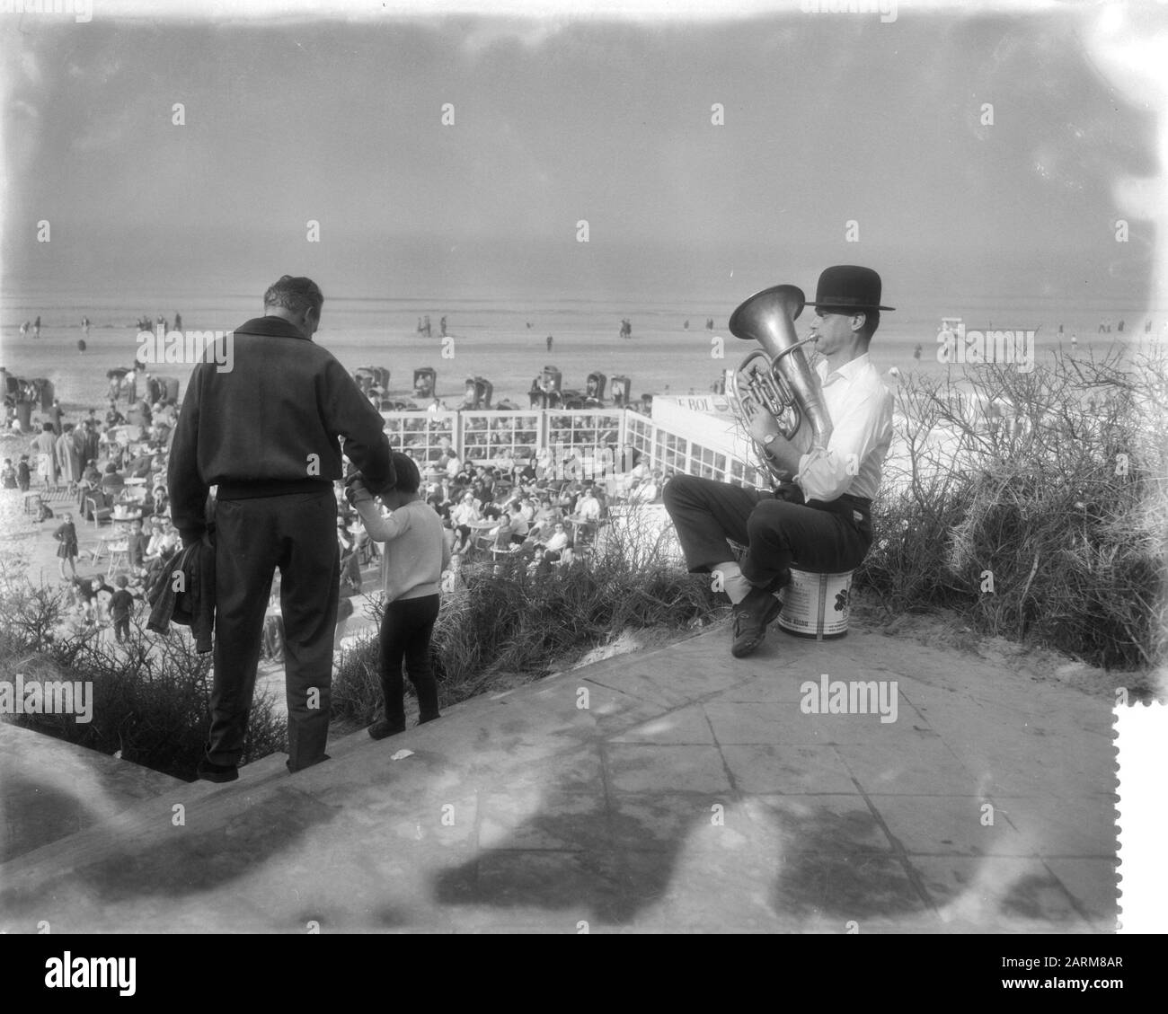 Occupé à la plage de Zandvoort en raison du beau musicien de temps avec tuba et chapeau de bowling Date: 1 mars 1959 lieu: Noord-Holland, Zandvoort mots clés: Musiciens, plages Banque D'Images