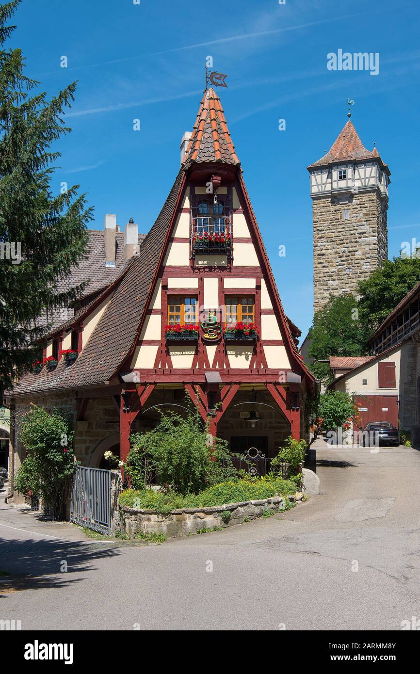 Rothenburg ob der Tauber, Allemagne - 23 juillet 2019; Maison de forgeron avec en arrière-plan une tour à la fois une attraction touristique dans la ville touristique Banque D'Images