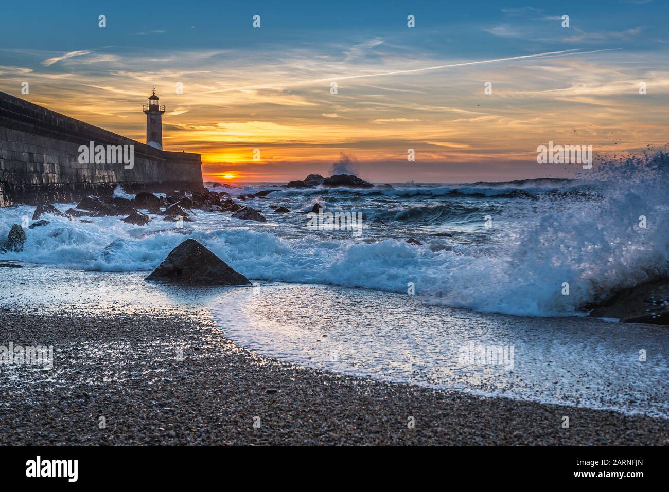 Vue depuis la plage de Carneiro sur un phare au coucher de soleil sur Felgueiras Océan Atlantique dans la région de Foz do Douro district de la ville de Porto, Portugal Banque D'Images