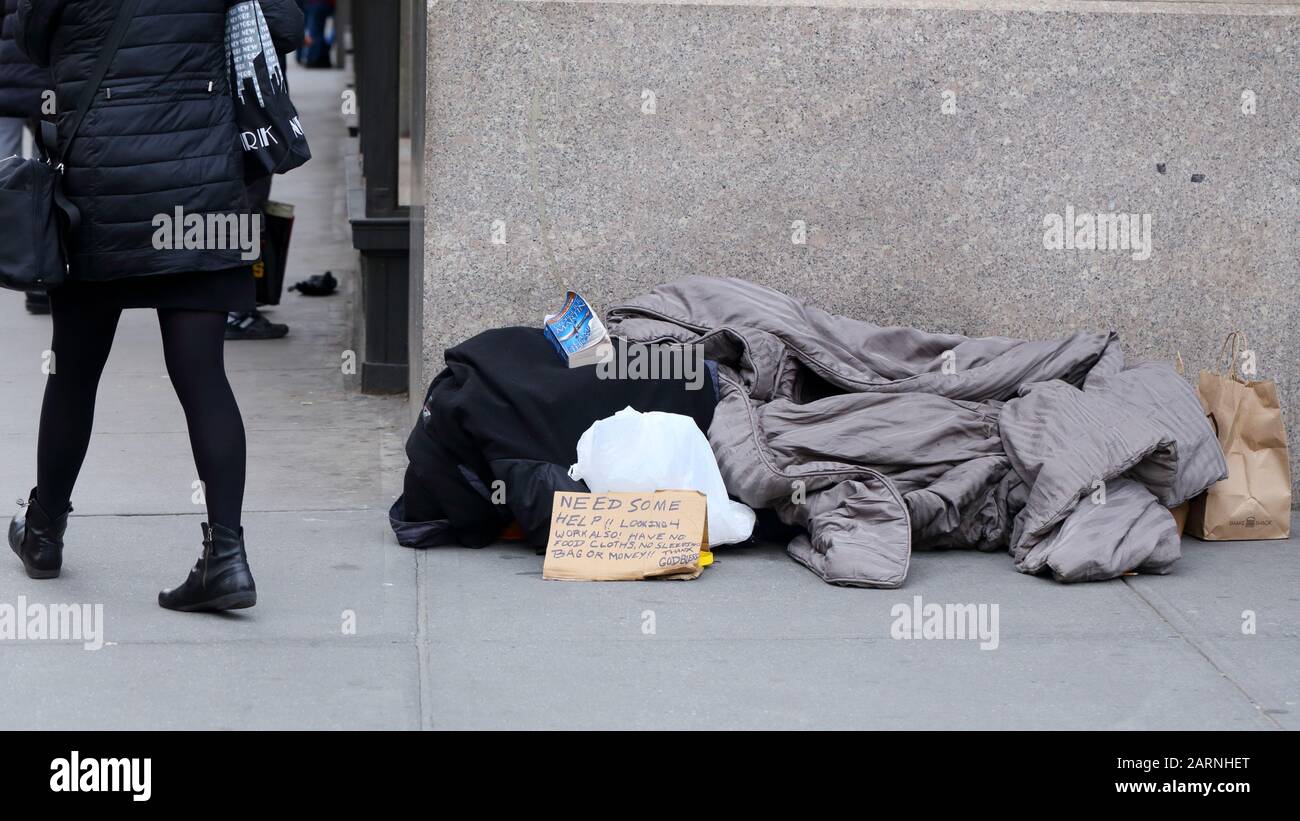 Une personne marche à côté des biens d'une personne sans abri à New York City Banque D'Images