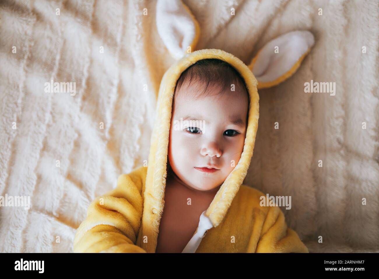 Un petit enfant avec un costume de lapin. Couché sur mauvais Banque D'Images