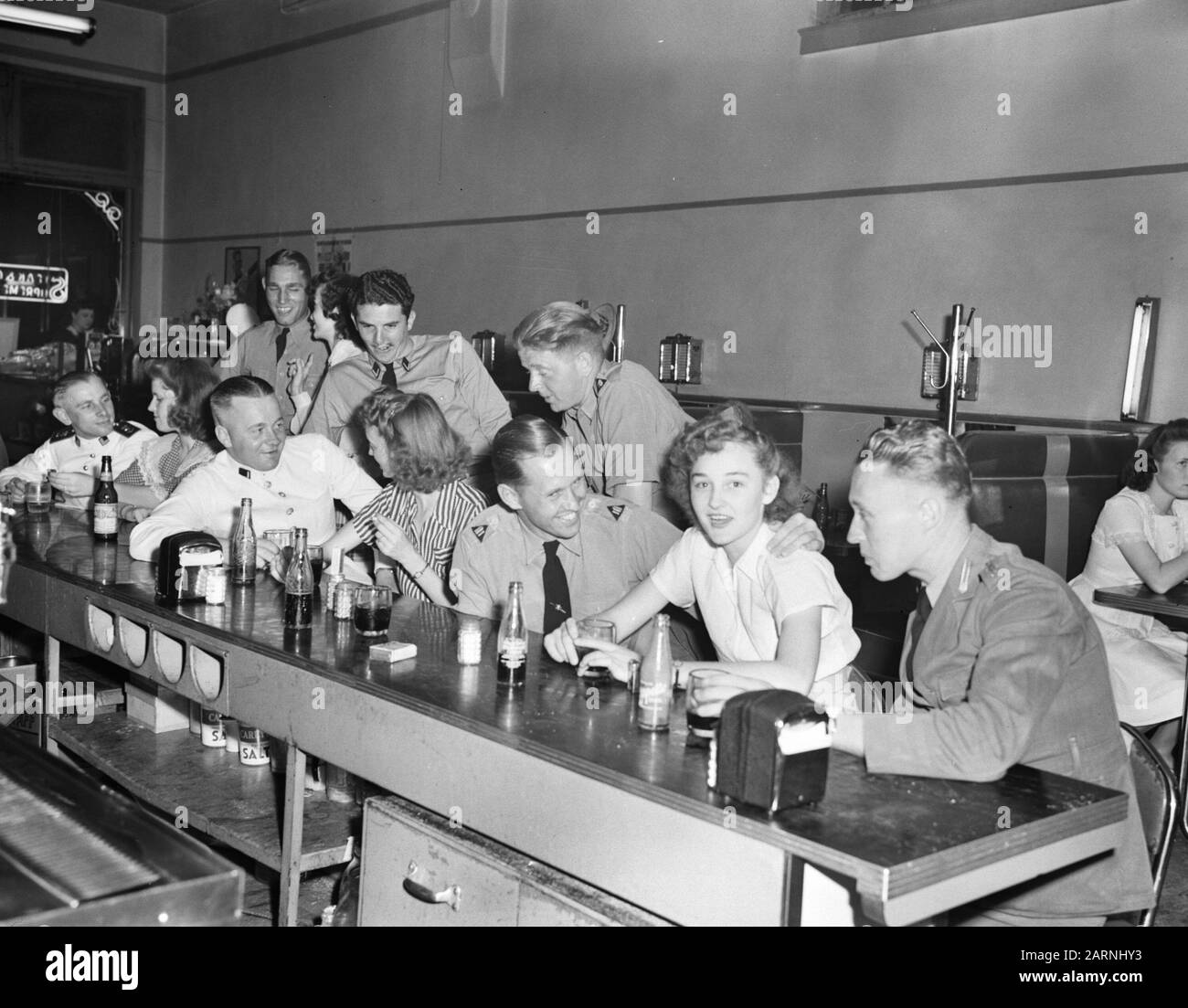 Royal Netherlands Military Flying School À Jackson, Mississippi. Les pilotes DU ML-KNIL, commandés par Le Général Majeur L.H. van Oyen, qui s'est échappé des Antilles néerlandaises de l'est, sont formés à fort Jackson, Mississippi. Un groupe d'étudiants néerlandais et leurs amies américaines se détendent après des heures de travail à un coca-cola dans un magasin de drogue à Jackson Annotation: 2 hommes au bar laissé en uniforme naval serait: Adriaan Manschot - né à Jaarsveld en 1916, mort le 9 février 1945 dans une collision entre deux Mitchells B25 au-dessus de Tienen (Tirlemont), Belgique. Il Était Date : 16 Juin 1942 Lieu : Jackson Army Air Base, Mi Banque D'Images