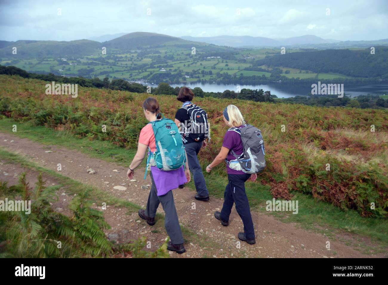 Trois femmes marchant sur une piste de Barton Sont Tombés au-dessus du lac Ullswater jusqu'au Wainwright 'Arthurs Pike' dans le parc national du district du lac, Cumbria. Banque D'Images