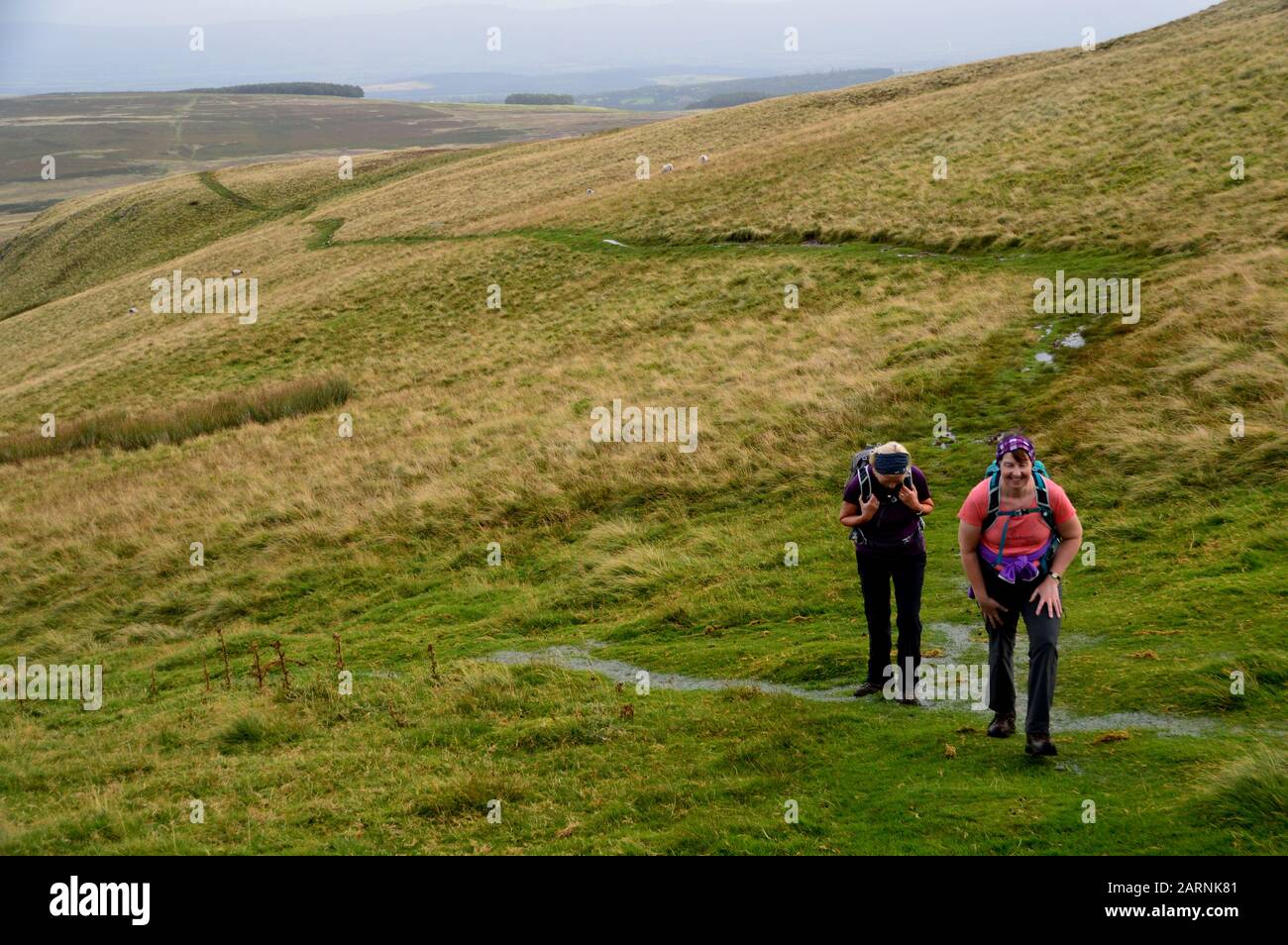 Deux femmes Randonneurs marchant sur la piste au-dessus de Barton Sont Tombés à Wainwright 'Arthurs Pike' dans le parc national du Lake District, Cumbria. Angleterre, Royaume-Uni. Banque D'Images