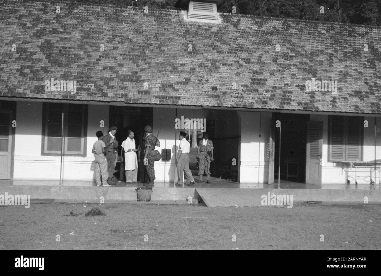 Djambi au début de la matinée du 30 décembre 1948 a été maraché par les troupes néerlandaises à Djambi (Sumatra). Cet endroit était occupé sans opposition à 8 heures. L'une des premières actions de l'armée néerlandaise a été la prise de contrôle de l'hôpital où les médecins et le personnel infirmier étaient encore présents. Après avoir reçu certaines instructions, ils sont tous revenus au travail Annotation: Opération magpie. À la tribune, certains soldats (parachutistes du groupe Para-combat) parlent avec un médecin Date: 30 décembre 1948 lieu: Indonésie, Antilles néerlandaises de l'est, Sumatra Banque D'Images
