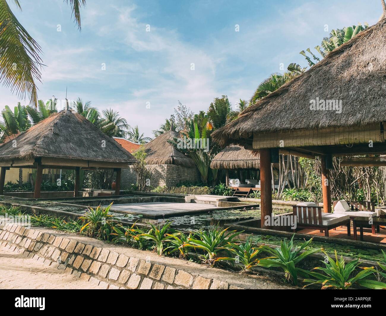 Bungalows au milieu d'une végétation tropicale, entourés de palmiers. Un endroit pour se détendre et méditer. Détendez-vous dans un paradis tropical Banque D'Images