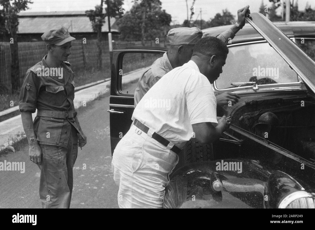Visitez le Colonel Julian en Indonésie Jokjakarta : l'ancienne voiture du Président Soekarno n'a pas de chance. Le colonel Julian est à la recherche de la cause. Annotation : le colonel noir américain b.d. Hubert F. Julian, un ancien pilote surnommé Black Eagle, a visité l'Indonésie en tant que journaliste. Il était farouchement anti-communiste et soutenait l'attitude néerlandaise dans le conflit. Date : Janvier 1949 Lieu : Indonésie, Antilles Néerlandaises De L'Est Banque D'Images