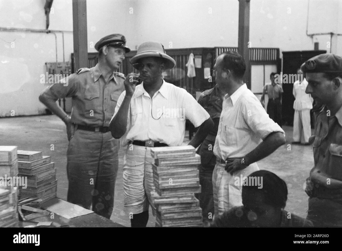 Visitez Le Colonel Julian À L'Usine De Cigares D'Indonésie À Jokjakarta. Le colonel Julian approuve le produit. Annotation : le colonel noir américain b.d. Hubert F. Julian, un ancien pilote surnommé Black Eagle, a visité l'Indonésie en tant que journaliste. Il était farouchement anti-communiste et soutenait l'attitude néerlandaise dans le conflit. Date : Janvier 1949 Lieu : Indonésie, Antilles Néerlandaises De L'Est Banque D'Images