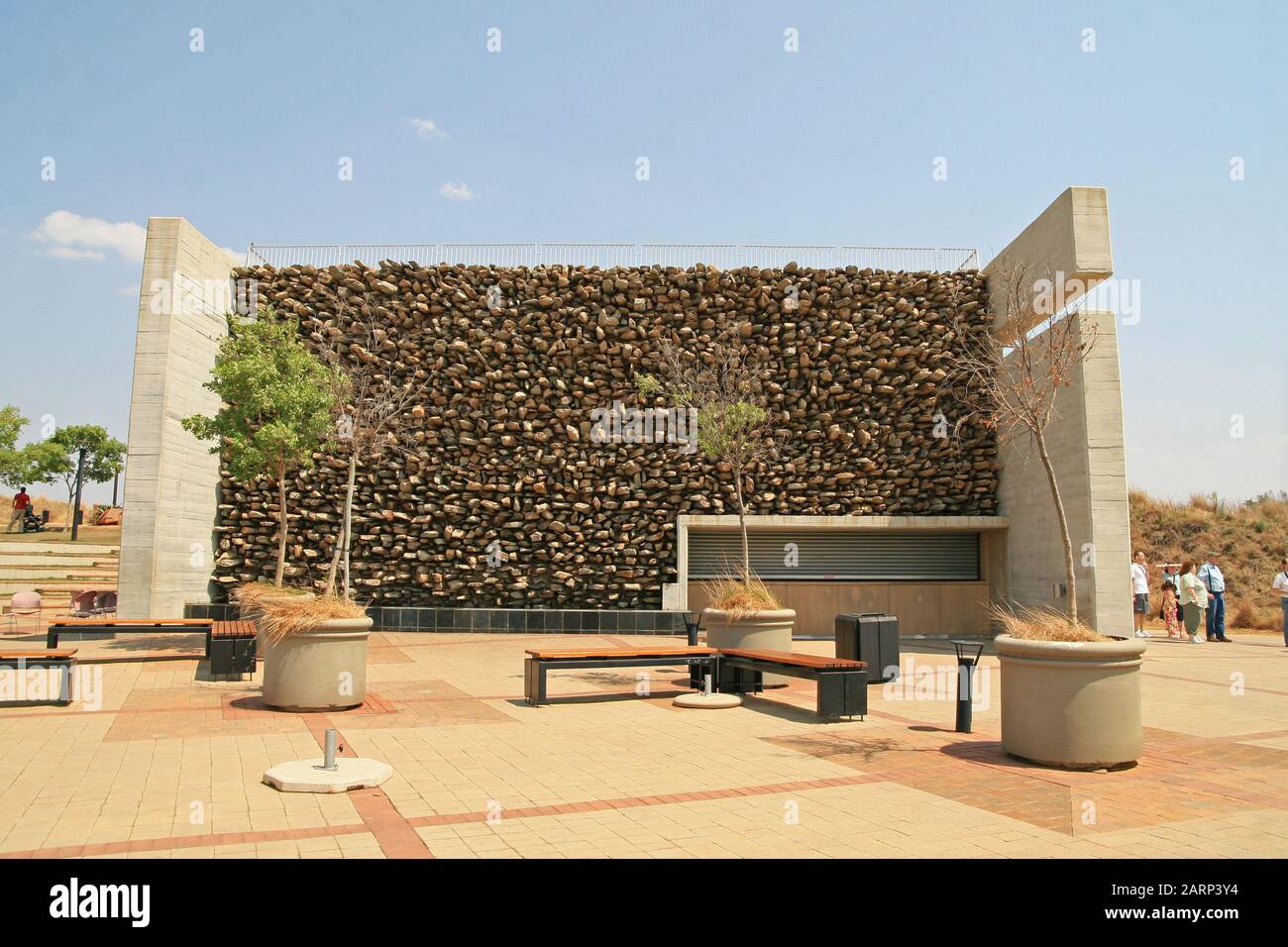 Groupe touristique à la construction avec mur de roche, au berceau De L'Humanité, Maropeng, Gauteng, Afrique du Sud. Banque D'Images