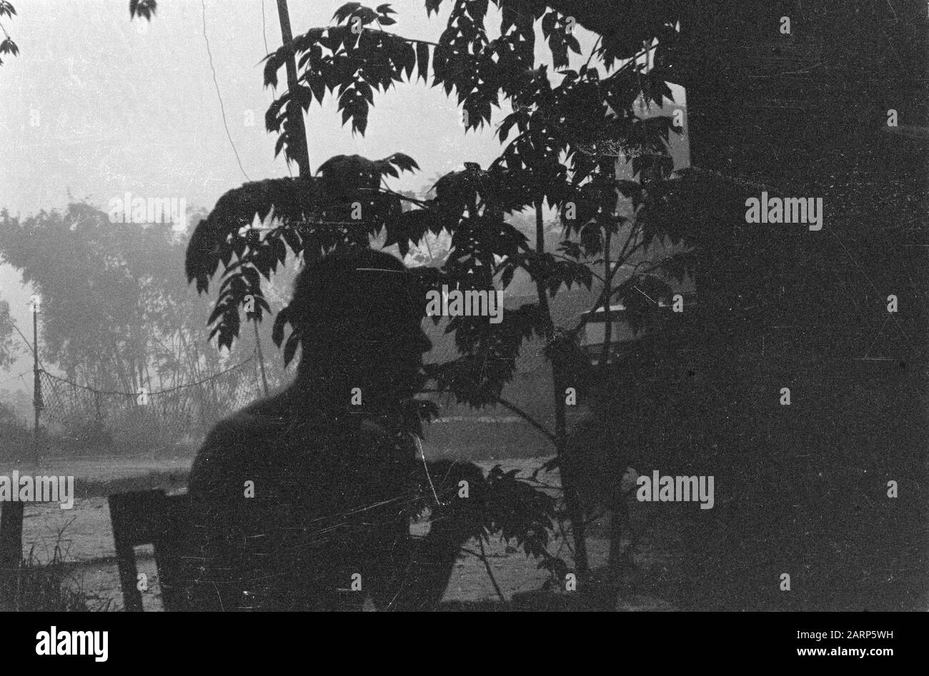 Le soldat est assis sur la terrasse. Un terrain de volley-ball est visible [l'image est sous-exposée] Date: 1947 lieu: Indonésie, Pays-Bas East Indies Banque D'Images