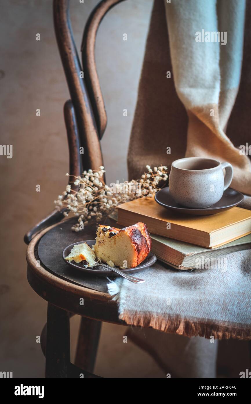 Petit-déjeuner sur une chaise rustique avec une tasse de café et un morceau de gâteau. Banque D'Images