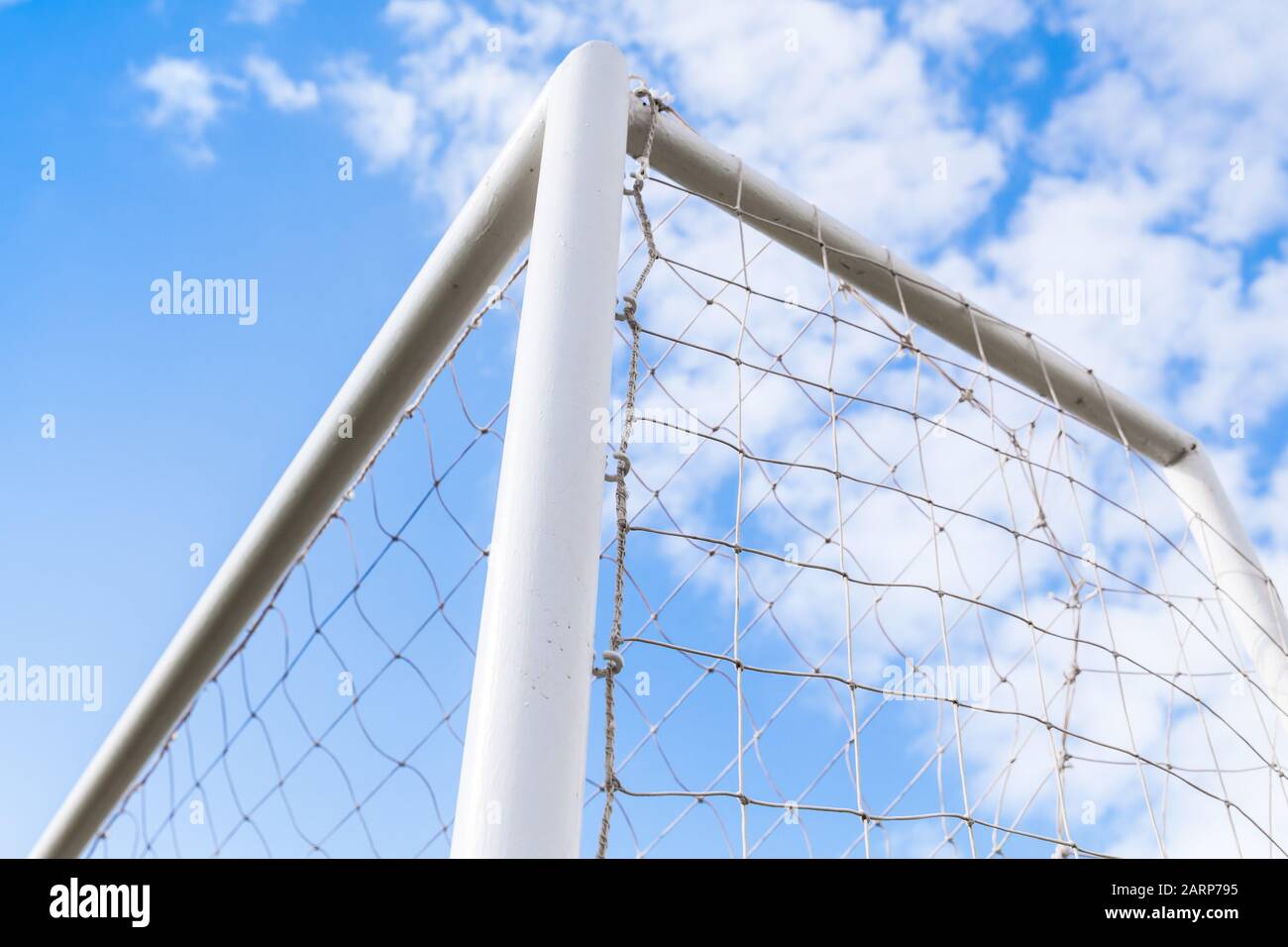 Coin de but de football blanc vide sous ciel bleu nuageux Banque D'Images