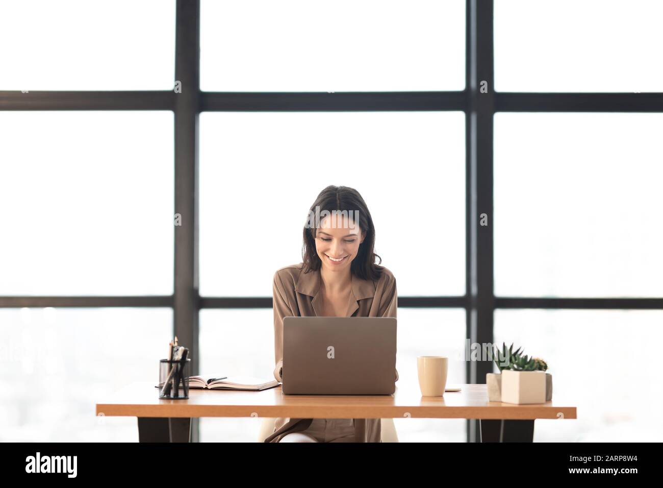 Belle fille travaillant sur son ordinateur portable au bureau moderne Banque D'Images