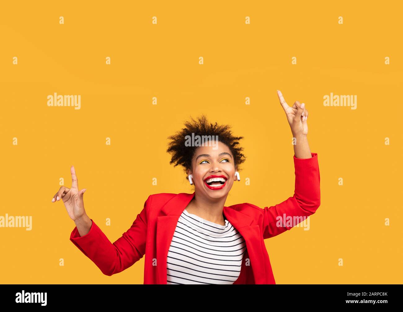 Une femme afro souriante qui écoute de la musique se met en avant Banque D'Images