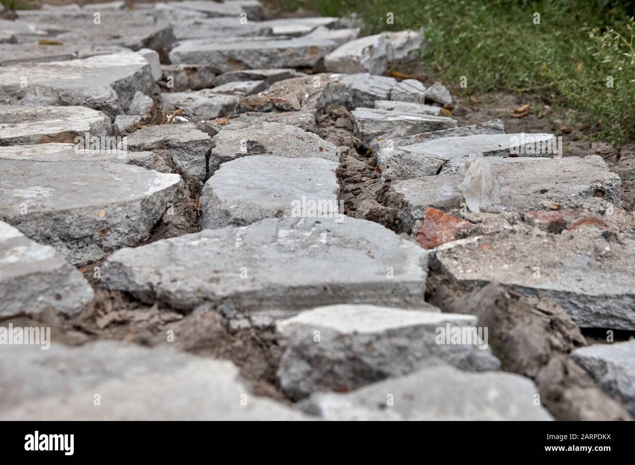 Morceaux de béton gris sur la route. Boue d'argile. Banque D'Images