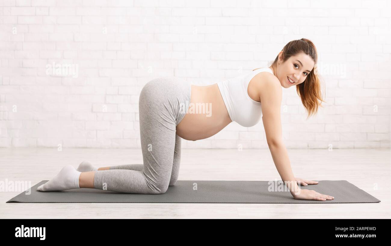 Femme enceinte apprenant la respiration droite sur tapis de yoga Banque D'Images