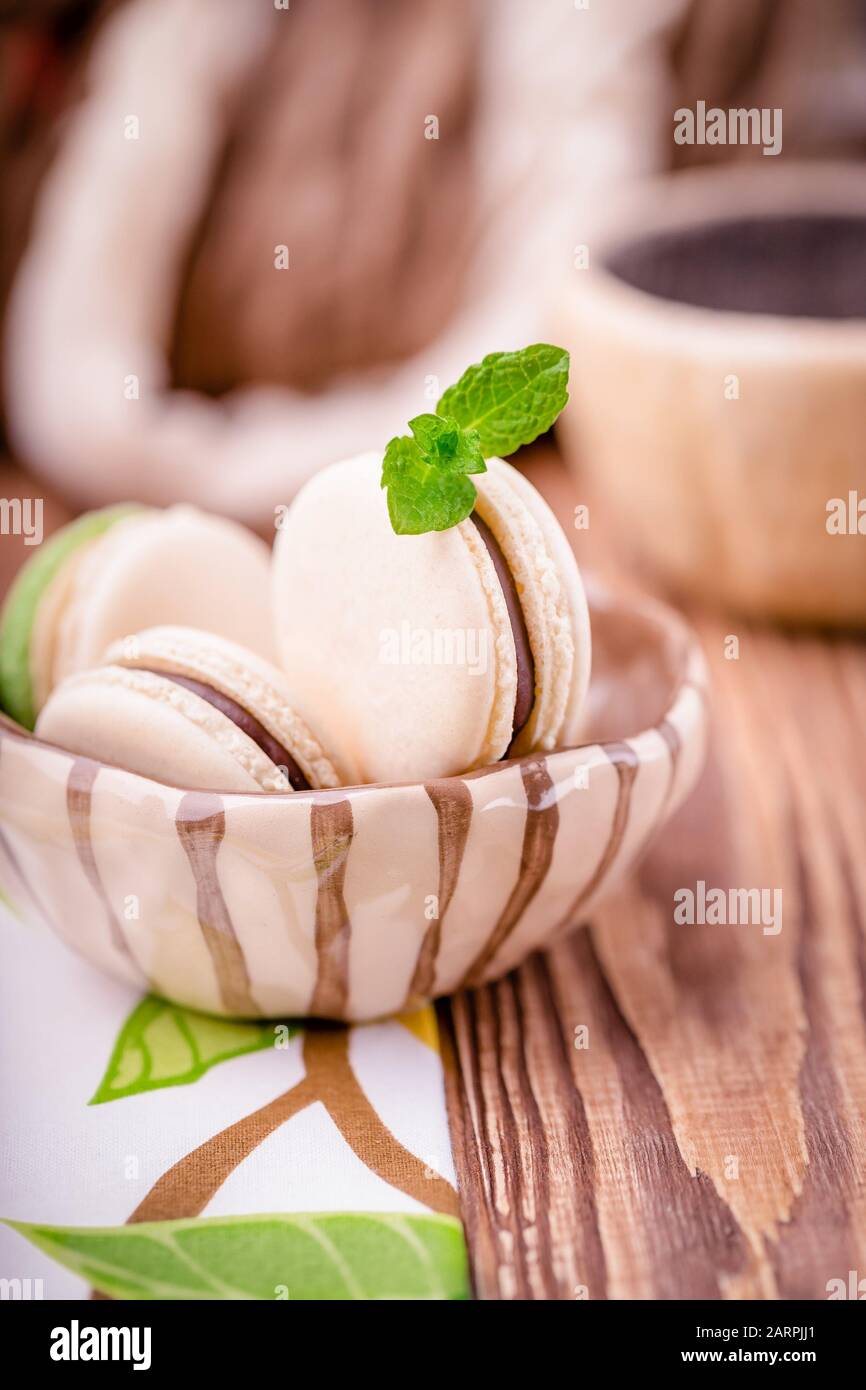Macaron ou macaron de chocolat à la vanille fait maison avec feuille de menthe sur fond en bois Banque D'Images