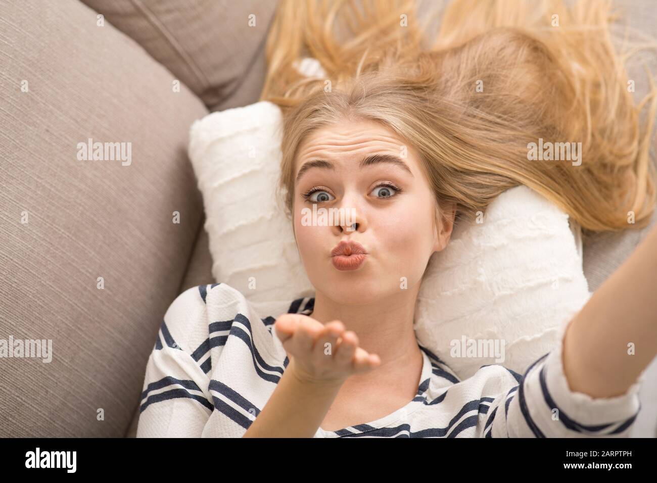 Jeune femme séduisante prenant selfie, envoyant un baiser de mouche Banque D'Images