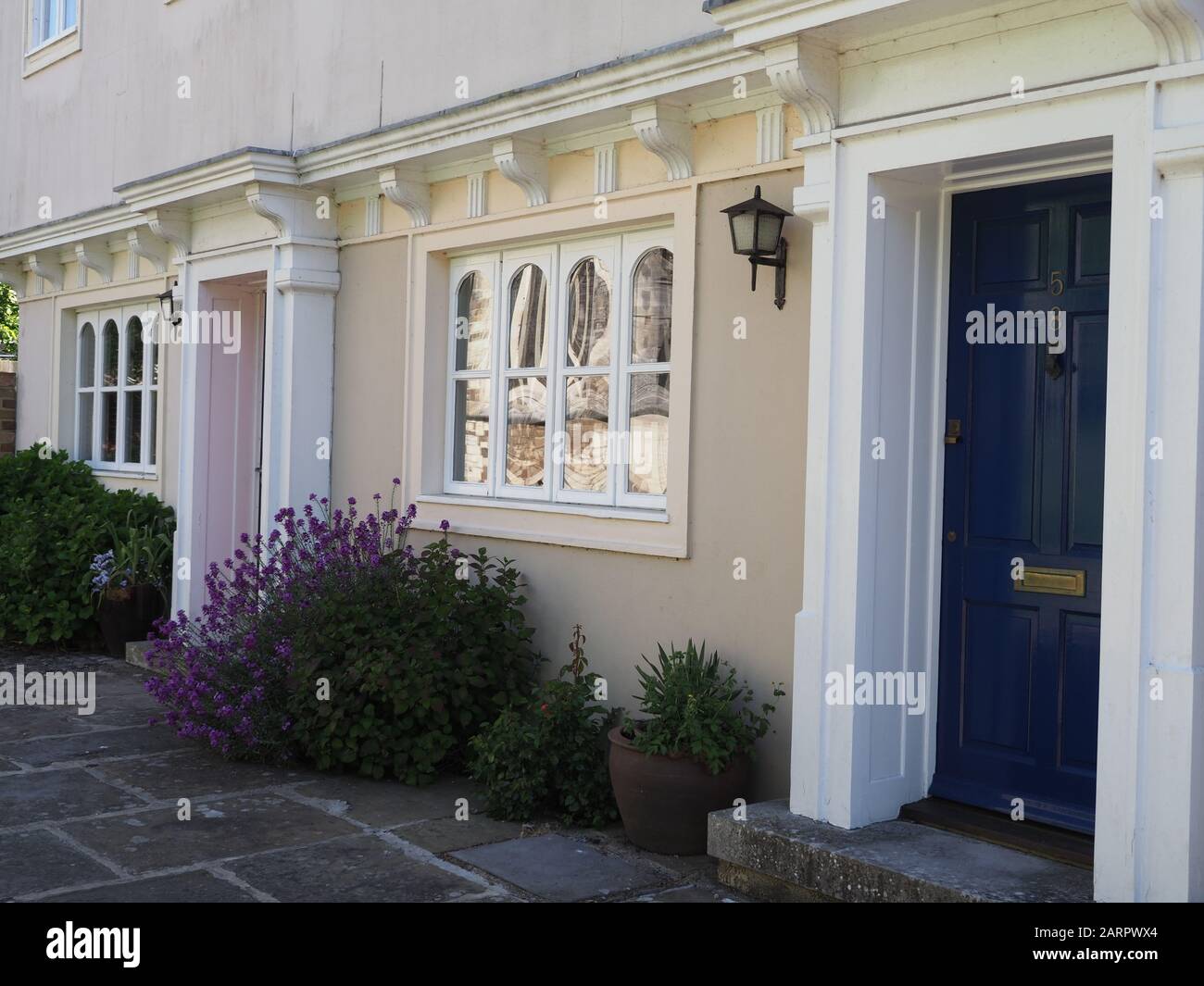 Rangée élégante de maisons près de l'église de Wimborne Ministre, Dorset, Royaume-Uni avec lavande en pots Banque D'Images