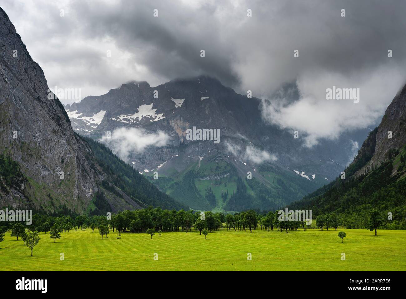 Nuages sombres avec pluie et illuminations ensoleillées sur les massifs rocheux de montagne et les érables du pâturage Grosser Ahornboden, Tyrol, Autriche, Europe Banque D'Images