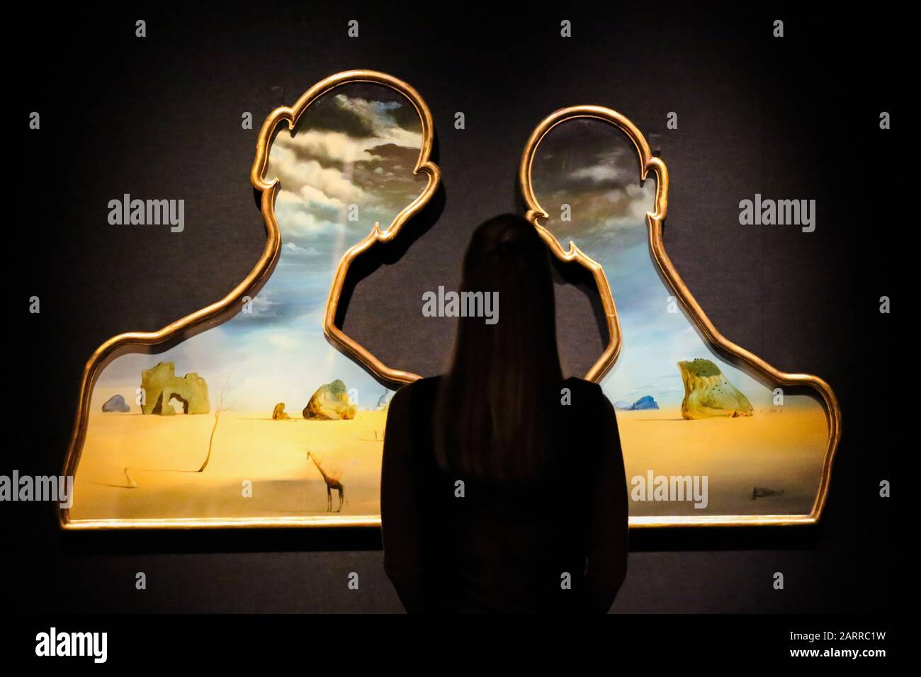 Bonhams, New Bond Street, Londres, Royaume-Uni 29 Jan 2020: - un membre du personnel voit Salvador Dal’, Couple aux ttes de plis nuages (1937) (est £7 à £10 m) à l'aperçu de Bonhams Impressionist et Modern Art Sale. Dal’ a créé Un Couple aux ttes de plis nuages (1937) alors qu’à Cadaqus pendant la guerre civile espagnole C au plus fort de sa période surréaliste (1929-1939). Les motifs surréalistes emblématiques interagissent avec la scène C rochers dispersés, un arbre défiguré, des figures humaines indistinctes, une girafe au feu et des nuages qui traversent les têtes des panneaux, ajoutent aux sous-courants de Freudien souvent incarnés dans Dal’ Banque D'Images