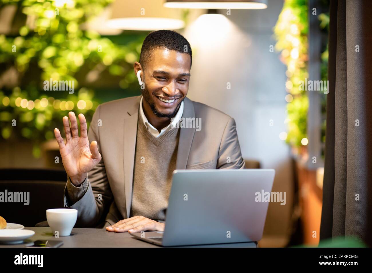 Homme d'affaires noir souriant faisant des appels vidéo à la famille Banque D'Images