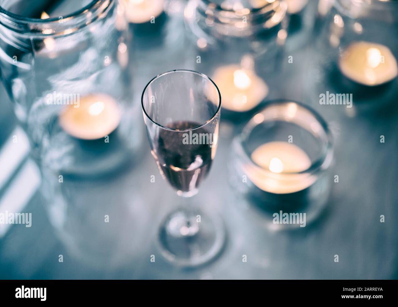 Vin rouge et bougies chauffe-plat dans des bocaux en verre. Banque D'Images