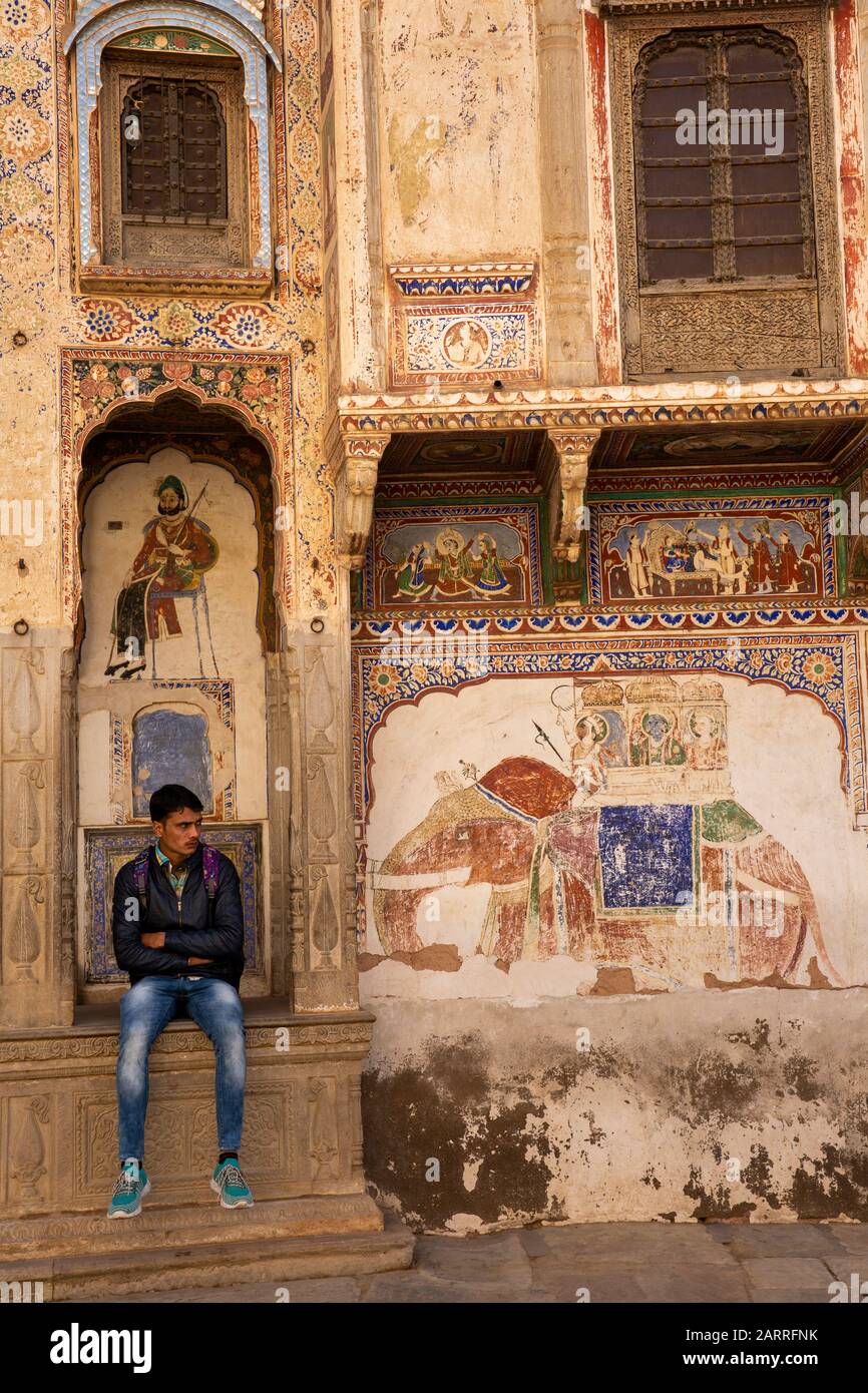 Inde, Rajasthan, Shekhawati, Nawalgarh, Nayabazaar, homme assis à l'extérieur de Haveli en mauvais état Banque D'Images