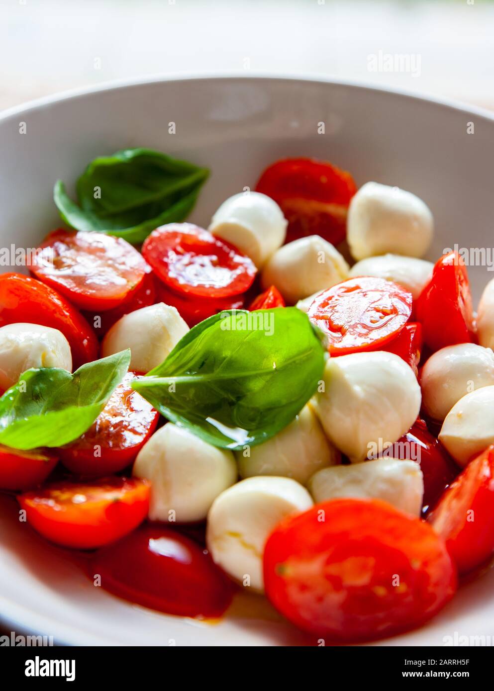 Gros plan d'un bol de salade de tomates avec mozzarella et basilic frais Banque D'Images