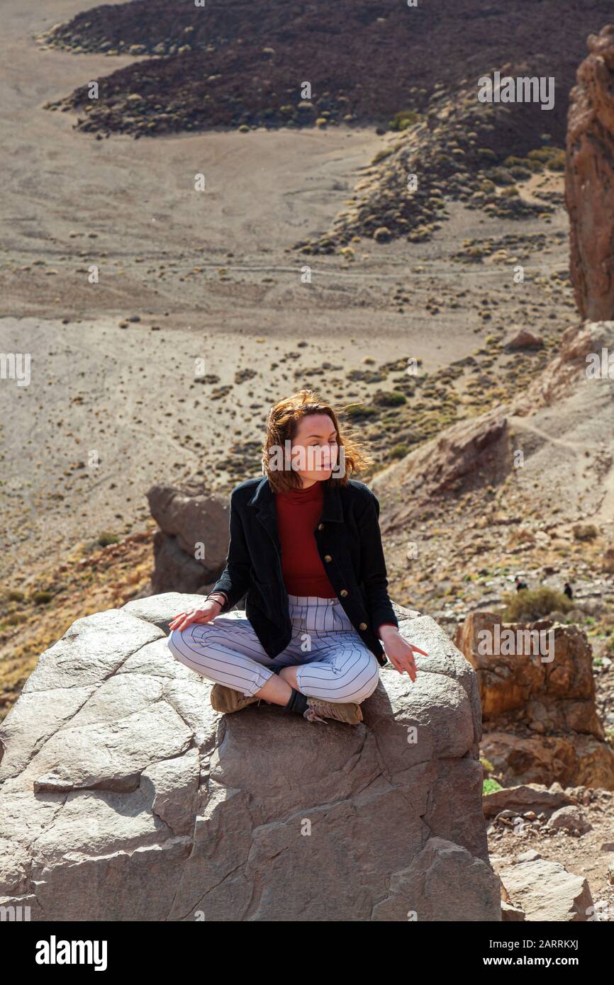 jeune femme méditant sur le affleurement rocheux au-dessus de la vallée Banque D'Images