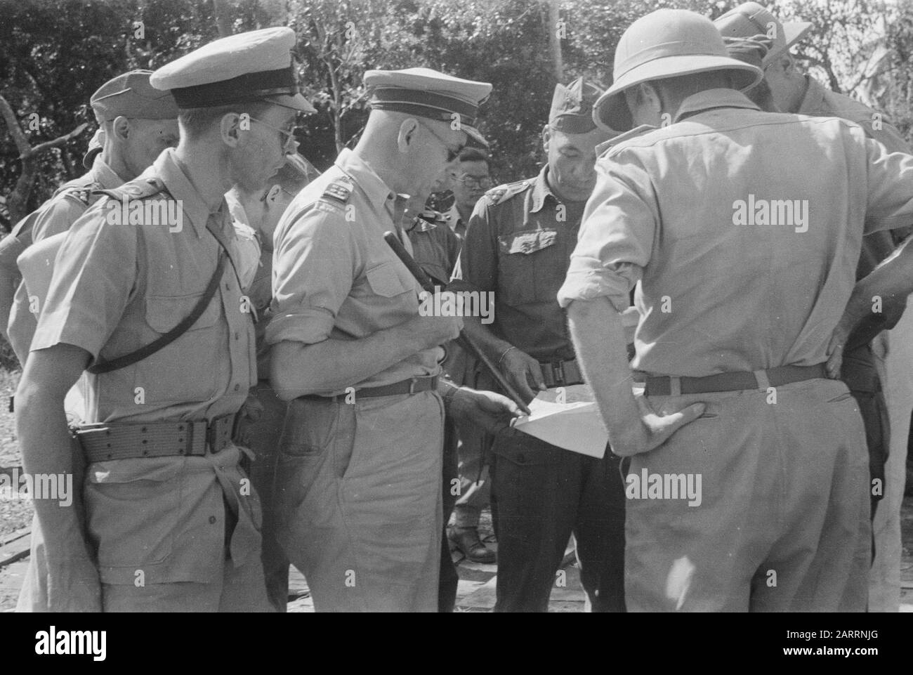 Visite du général S.H. Spoor et lieutenant-gouverneur général H.J. van Mook aux détachements à l'ouest de Batavia S.H. Spoor (avec bâton) et H.J. van Mook (avec casque Tropenheat) étudient une carte Annotation: Près de Rail lieutenant-ter-mer 1ère classe W. Langeraar. Au milieu, un capitaine de la KNIL Date : 6 juin 1946 lieu : Indonésie, Antilles néerlandaises de l'est Banque D'Images