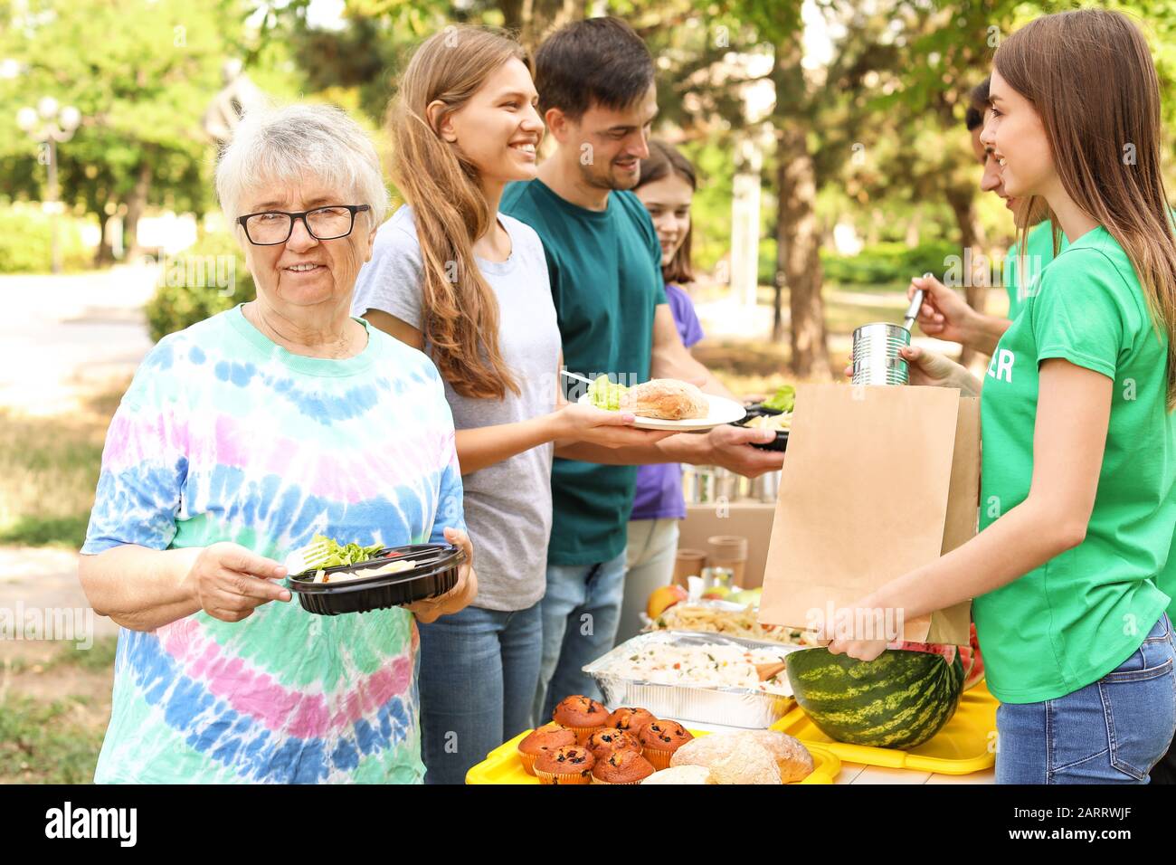 Les jeunes bénévoles en donnant de la nourriture aux pauvres à l'extérieur Banque D'Images