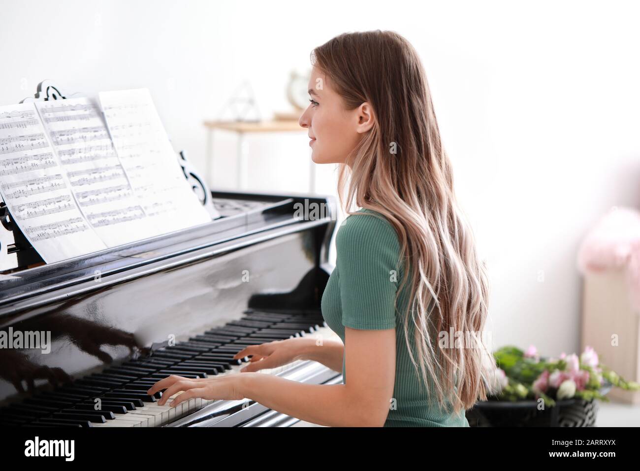Jeune femme jouant au piano à queue à la maison Photo Stock - Alamy
