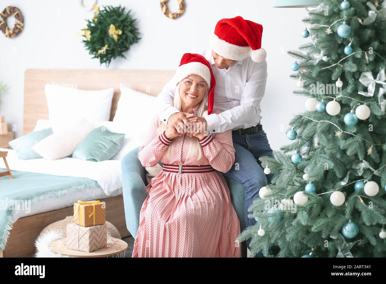Heureux couple d'âge mûr célébrant Noël à la maison Banque D'Images