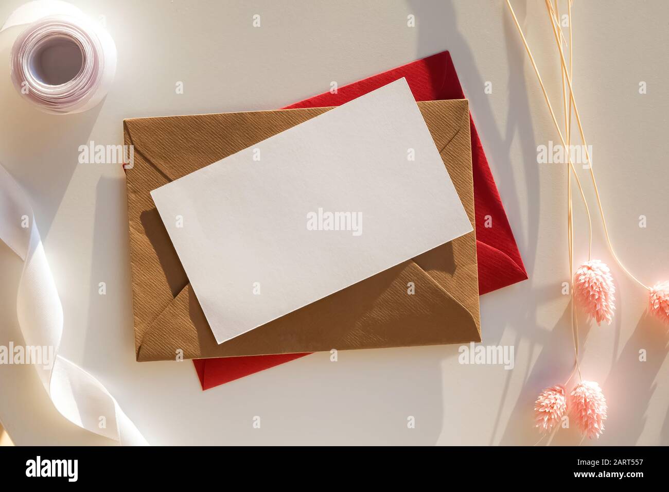 Carte de papier vide mock-up sur la table avec des fleurs sèches et ruban de lumière naturelle Banque D'Images