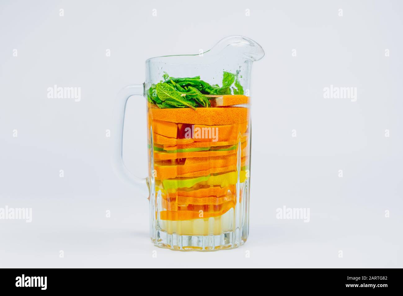 Grand bol en verre avec agrumes et menthe sur fond blanc. Limonade aux oranges, citron vert et citrons. Boisson aux fruits riche en vitamines et en santé Banque D'Images