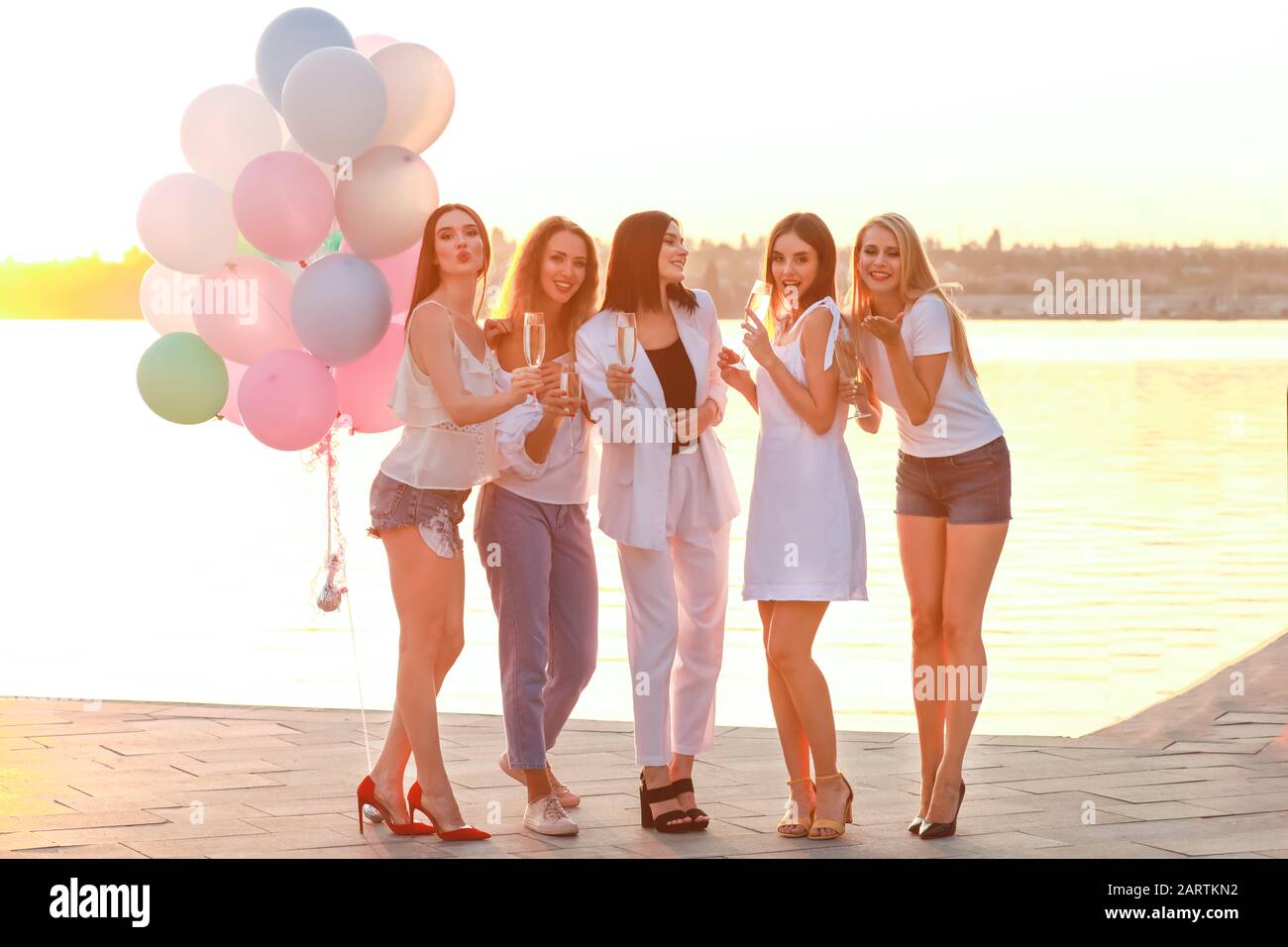 Belles jeunes femmes avec champagne à la fête de la poule près de la rivière Banque D'Images