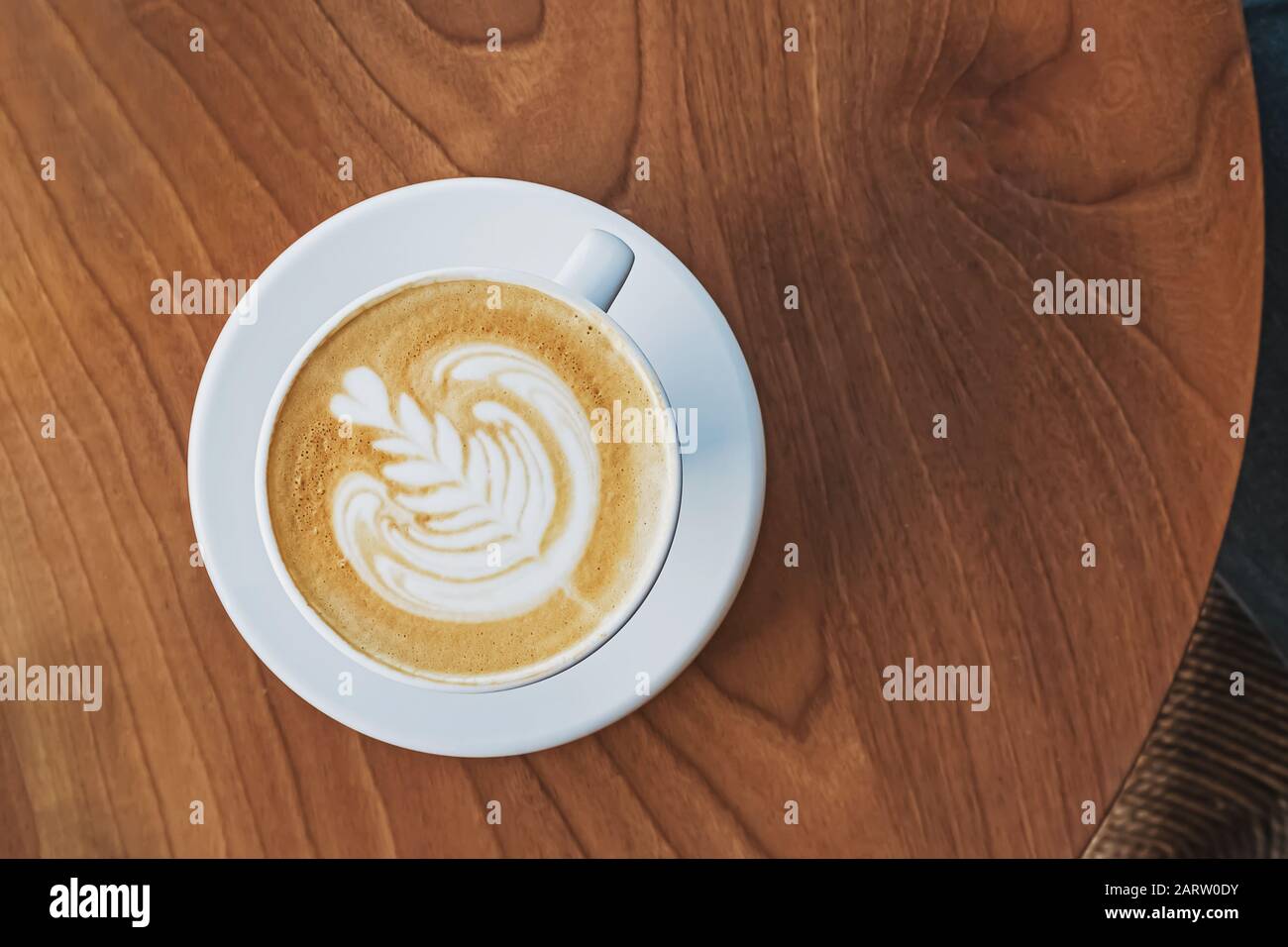 Une tasse de café avec latte art sur la table en bois Banque D'Images