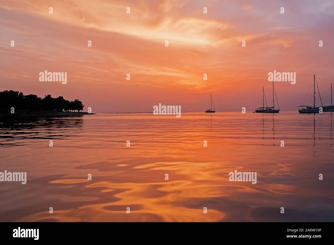 Beau coucher de soleil au port avec yachts à la distance. Banque D'Images