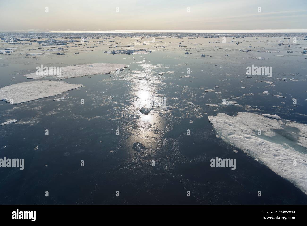 Flotteurs de glace et réflexion solaire dans l'océan Arctique au nord de Svalbard, Norvège Banque D'Images