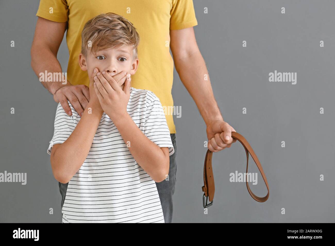 Homme avec ceinture et son petit fils peur sur fond gris. Concept de  punition physique Photo Stock - Alamy