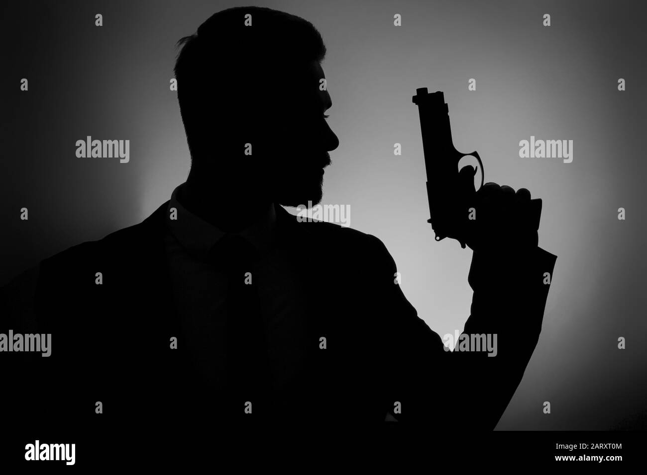Silhouette d'agent mâle avec canon sur fond sombre Banque D'Images