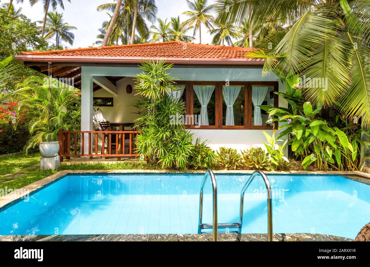 Sri Lanka - 31 octobre 2017: Villa avec piscine dans un hôtel tropical. Piscine avec eau bleue propre dans un jardin luxueux. Belle arrière-cour ensoleillée Banque D'Images