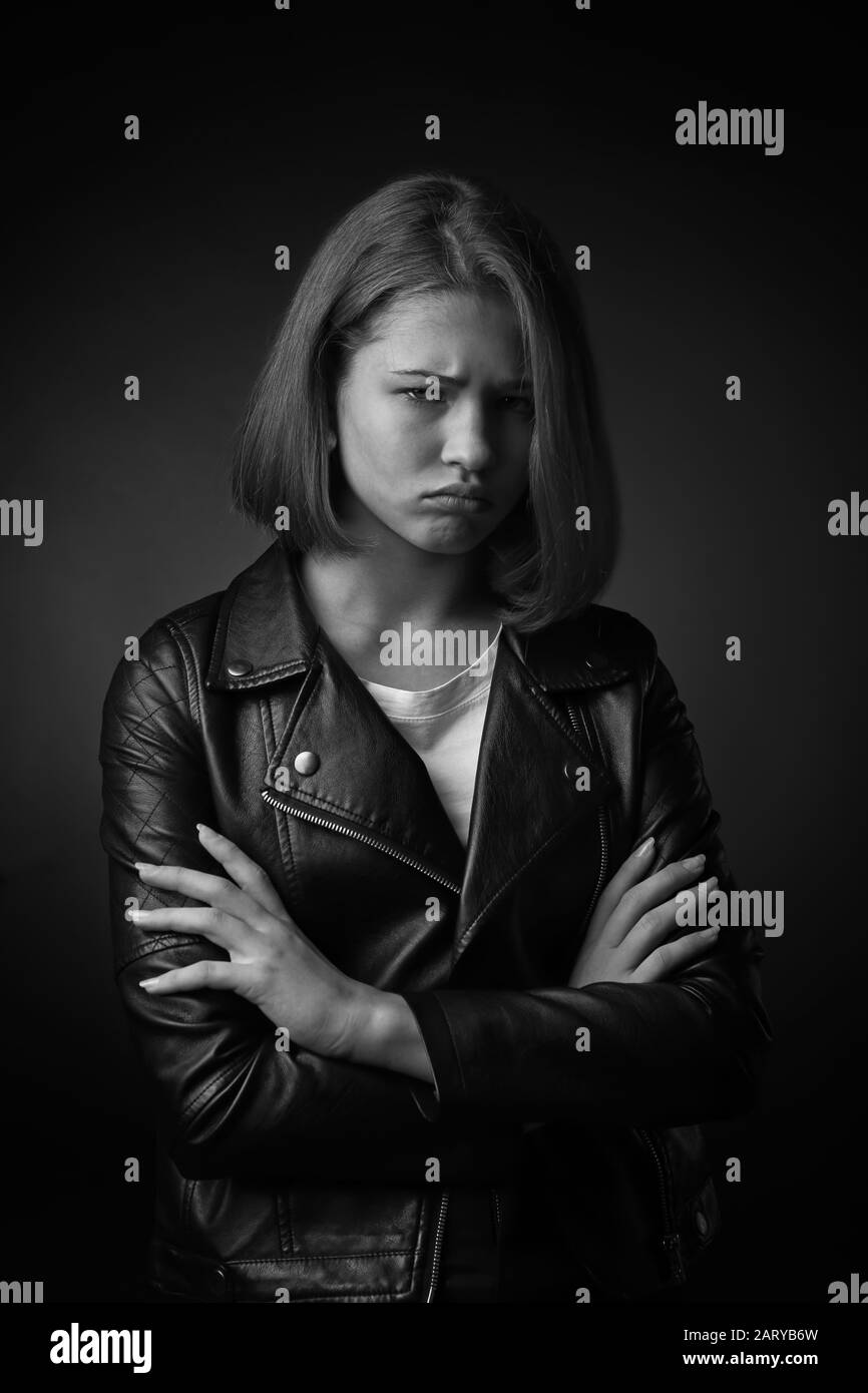 Portrait noir et blanc d'une adolescente dévoyée sur fond sombre Banque D'Images