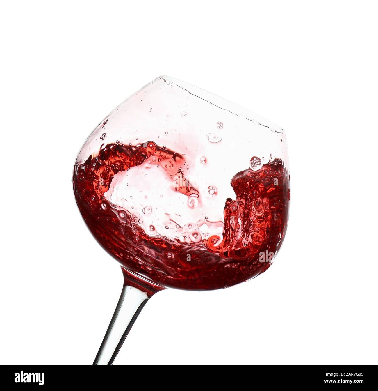 Verre avec vin rouge éclaboussant sur fond blanc Banque D'Images