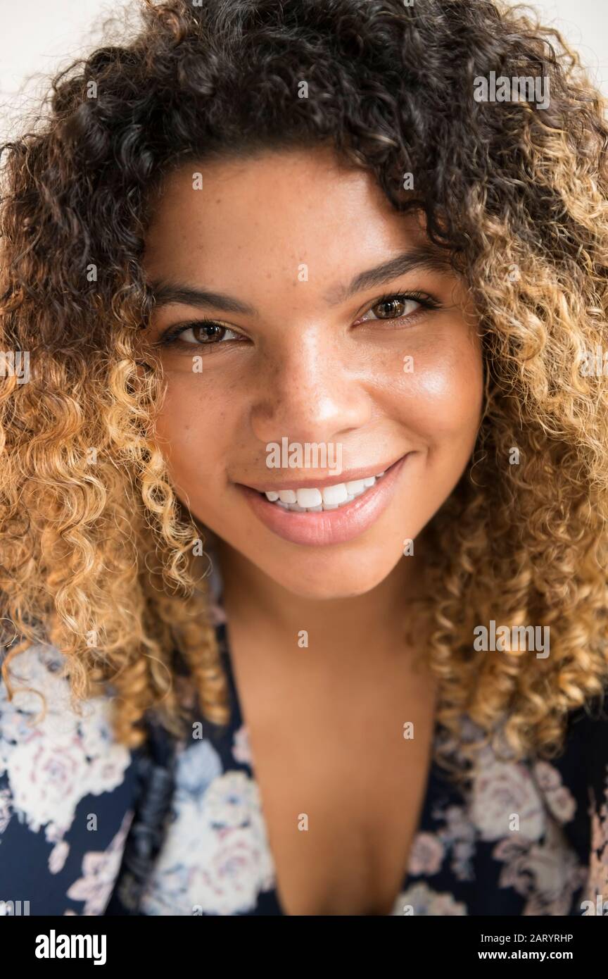 Femme souriante avec des cheveux bouclés Banque D'Images