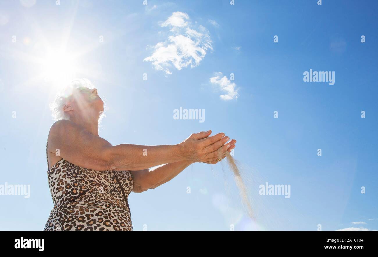Photo à angle bas d'une femme tenant du sable Banque D'Images